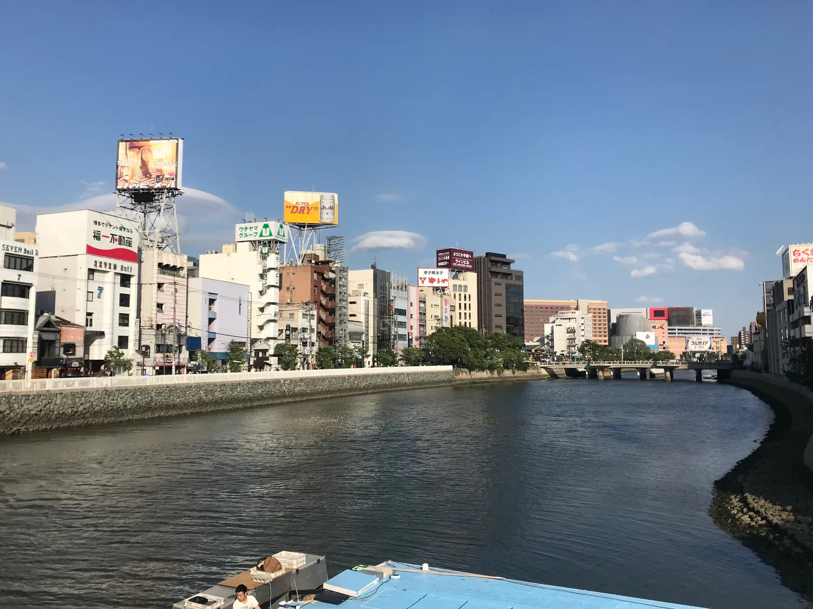 Yatai food stalls glowing along the Naka River at night in Fukuoka's Nakasu district