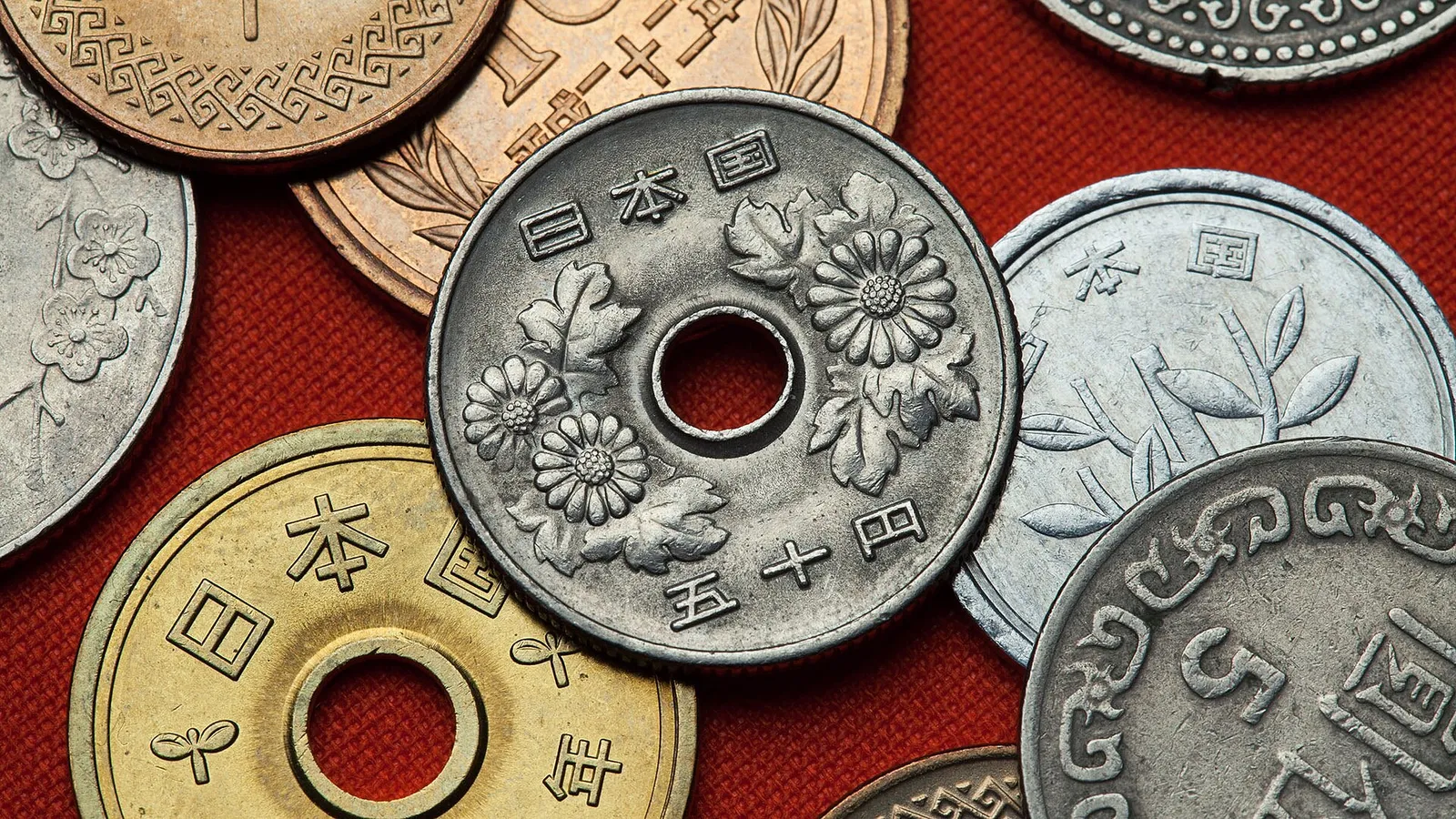 Japanese yen banknotes and coins arranged on a wooden counter