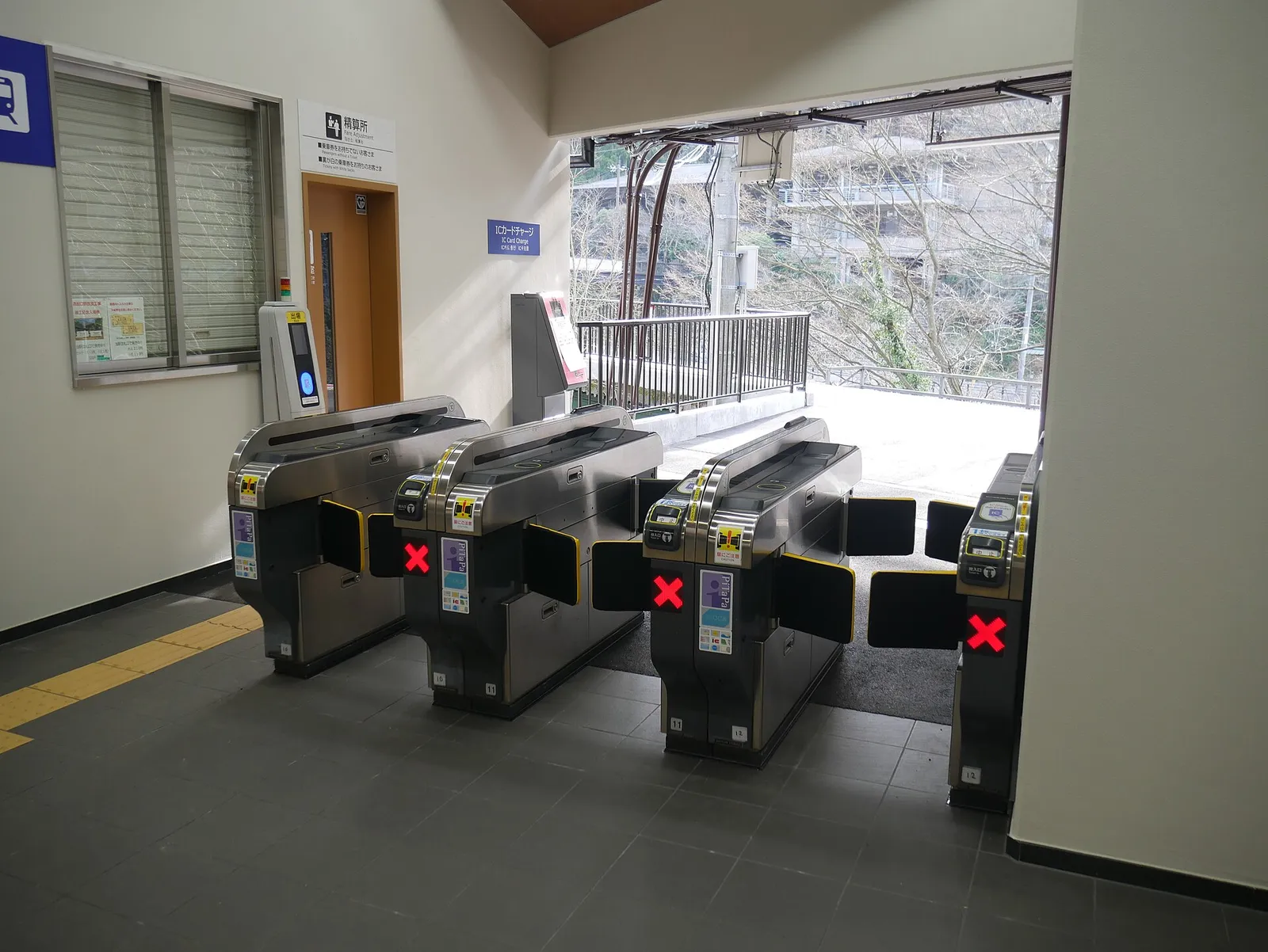 Commuters passing through automatic ticket gates with IC cards at a Japanese train station