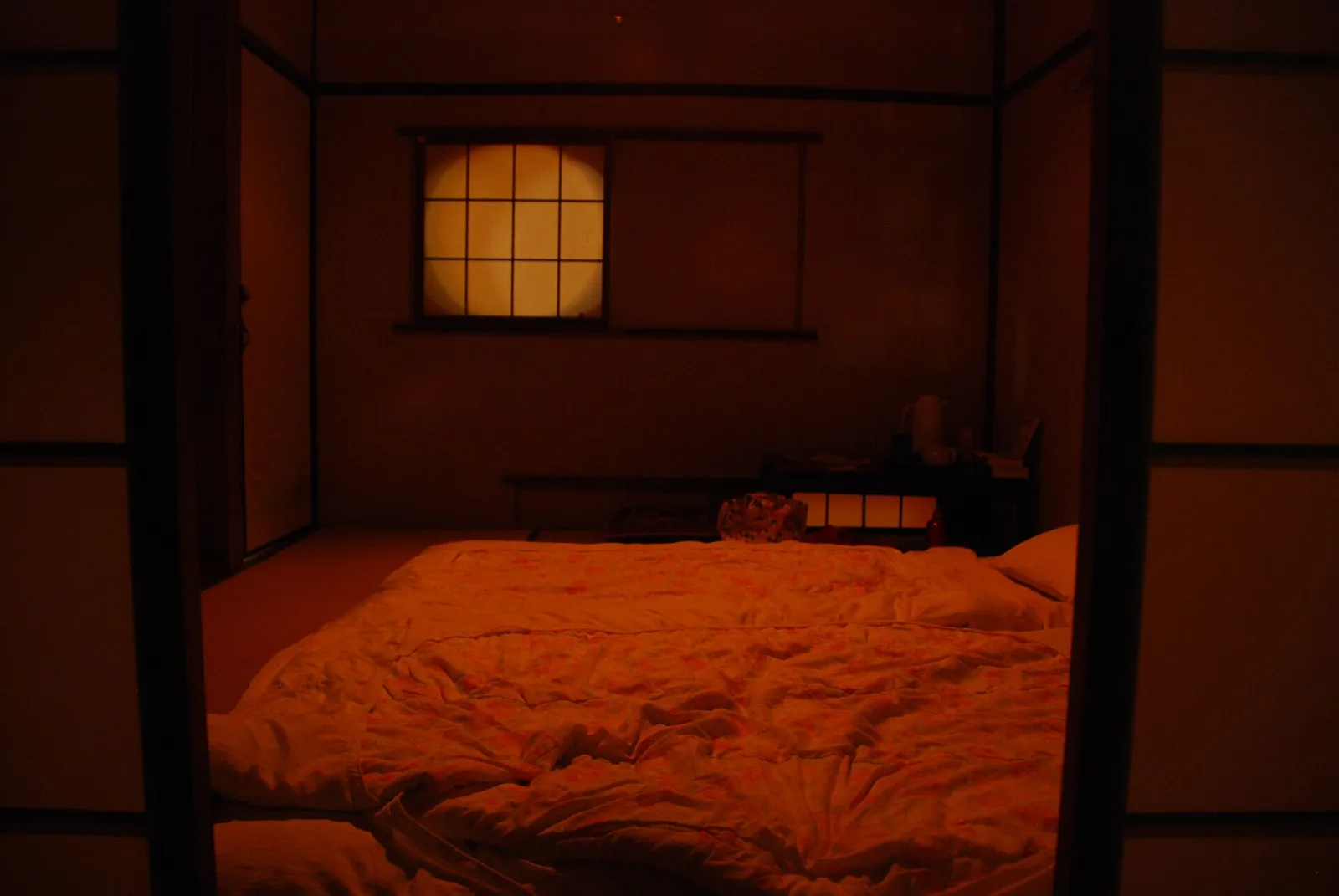 Traditional Japanese tatami room with futon bedding, low table, and paper shoji screens